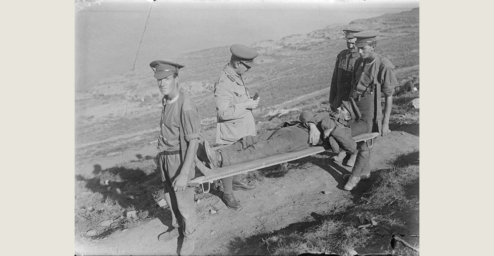 Brigadier-General Felix Frederic Hill, the Commander of the 31st Brigade (10th Irish Division), speaking to a man wounded by shrapnel who is being taken away on a stretcher