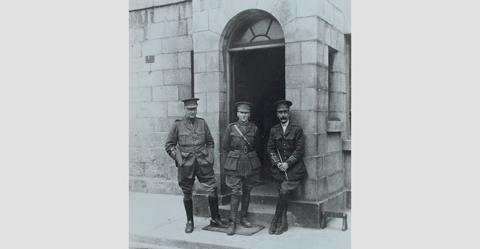 Three of the soldiers stand at a doorway in the Royal Barracks
