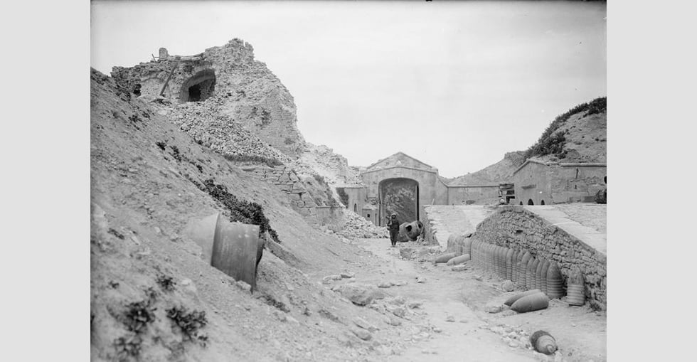 A view of the old port at Sedd el Bahr, Cape Helles, showing damage caused by the naval bombardments prior to the Gallipoli landings in 1915. A British soldier stands on sentry amongst the ruins of the old gate.
