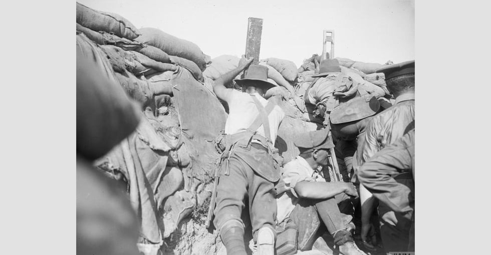 Men of the Royal Naval Division and Australians in the same trench. One is using a 'sniperscope' and another a periscope.