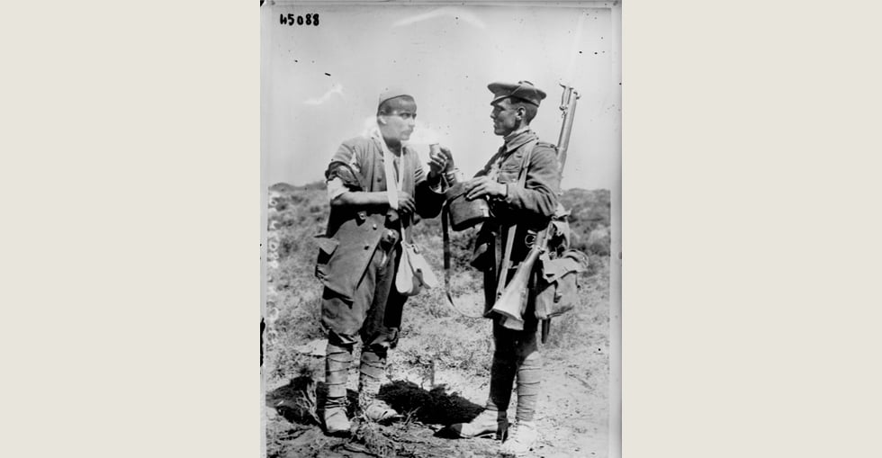 English soldier giving water to a Turkish prisoner