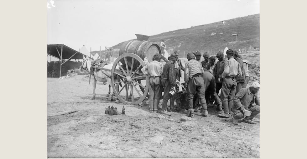 Turkish prisoners, captured during the Gallipoli campaign, drawing water from a water-cart in the French Sector of V Beach at Sedd el Bahr, Cape Helles.