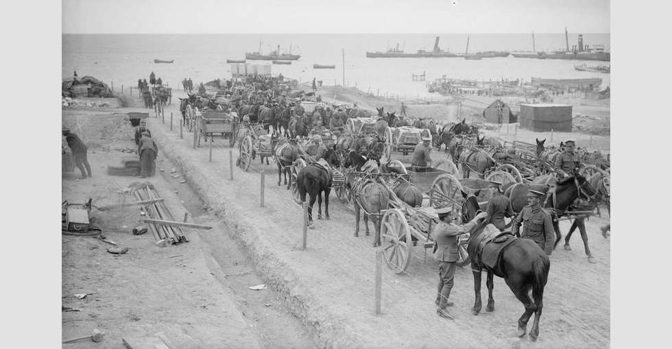 Water carts and other vehicles waiting for their turn to draw the water ration from the tanks on the coast